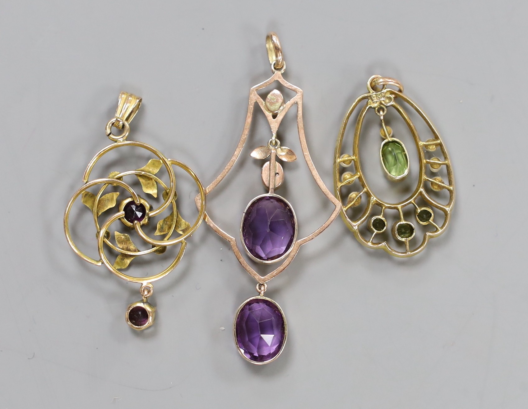 Three assorted yellow metal and gem set drop pendants including a 9ct, peridot and seed pearl, 33mm, gross weight 8 grams.